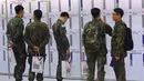 Tentara Korea Selatan membaca informasi pekerjaan saat mengikuti job fair di ruang pameran KINTEX, Goyang, Korea Selatan, Rabu (20/3). Job fair ini diharapkan dapat menarik sekitar 20.000 tentara yang akan segera diberhentikan. (JUNG Yeon-Je/AFP)