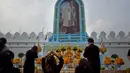 Warga Thailand memberi penghormatan di depan potret mendiang Raja Thailand Bhumibol Adulyadej di luar Grand Palace, Bangkok, Thailand (13/10). Upacara ini untuk memperingati satu tahun wafatnya Raja Bhumibol Adulyadej. (AP Photo/Gemunu Amarasinghe)
