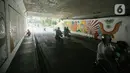 Kendati sedang ada pengerjaan mural, arus lalu lintas di lokasi tersebut tidak terganggu dan tetap lancar. (Liputan6.com/Faizal Fanani)