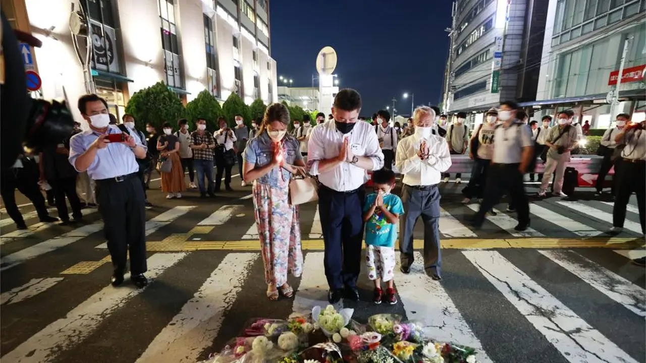 Orang-orang berdoa di lokasi mantan Perdana Menteri Jepang Shinzo Abe ditembak saat pidato di Nara, Jumat, 8 Juli 2022. (Kyodo News via AP)