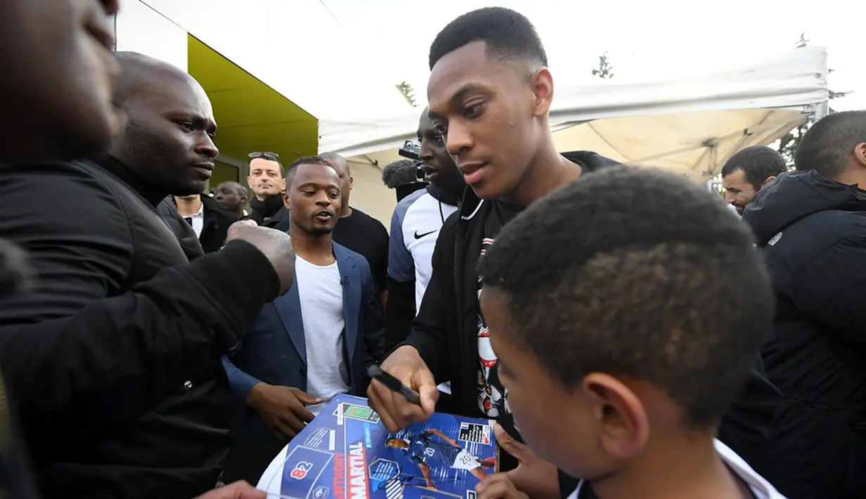 Pemain Timnas Prancis, Patrice Evra dan Anthony Martial, disambut meriah saat tiba di lapangan Les Ulis, (23/5/2016). Les Ulis adalah klub masa kecil keduanya. (AFP/Franck Fife) 