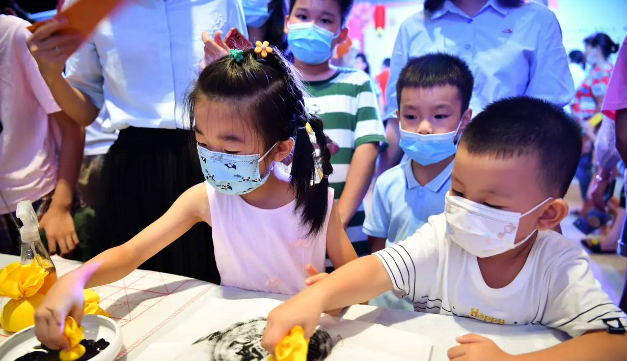 Anak-anak menjajal membuat sablon (rubbing) dalam acara perayaan Festival Pertengahan Musim Gugur di Museum Hainan, Haikou, ibu kota Provinsi Hainan, China selatan (1/10/2020). (Xinhua/Guo Cheng)