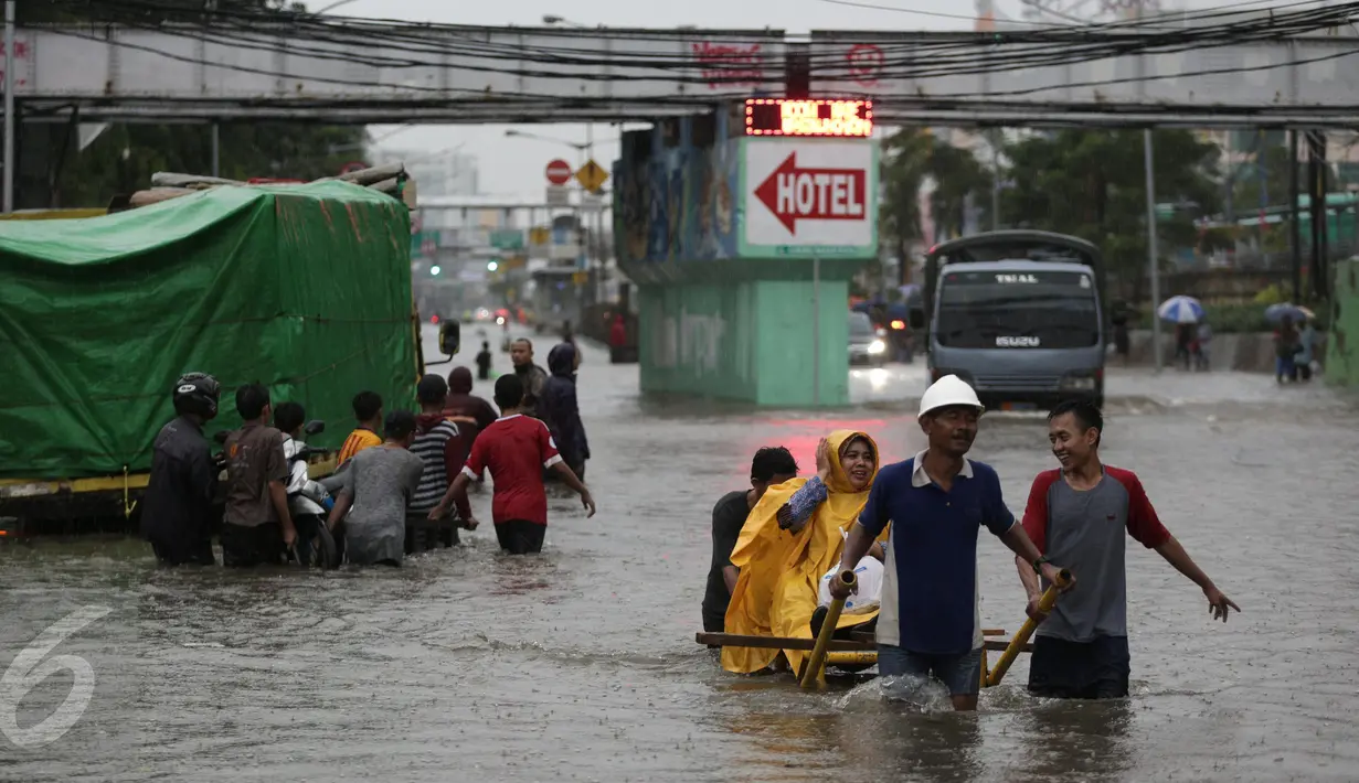 Warga menaiki gerobak untuk menyeberangi banjir yang merendam Jalan Gunung Sahari, Jakarta Pusat, Selasa (21/2). Hujan yang turun sejak dini hari menyebabkan sejumlah ruas jalan terimbas banjir dan tak bisa dilalui kendaraan. (Liputan6.com/Faizal Fanani)