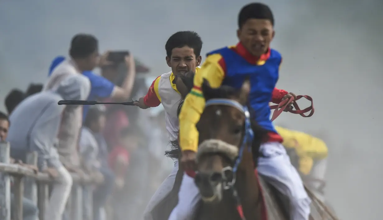 Para joki memacu kuda pada lomba pacuan kuda tradisional di Takengon, provinsi Aceh, 2 Maret 2019. Pacuan kuda tradisional di dataran tinggi Gayo Aceh telah menjadi salah satu kegiatan wisata andalan. (CHAIDEER MAHYUDDIN/AFP)