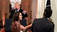Presiden AS, Donald Trump mengarahkan telunjuk ke jurnalis CNN Jim Acosta saat seorang staf mencoba menarik mikrofon darinya dalam konferensi pers di Gedung Putih, Rabu (7/11). Ketegangan bermula dari pertanyaan sang wartawan soal imigran. (AP/Evan Vucci)