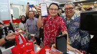 Wakil Menteri Perdagangan RI Jerry Sambuaga (tengah) didampingi Presiden Direktur OVO Karaniya Dharmasaputra (kiri) menunjukkan notifikasi pembayaran yang telah diproses usai melakukan pemindaian barcode QRIS OVO pada layar handphone pelanggan di sela Peluncuran QRIS CPM OVO di Toko Alfamart Patal Senayan, Jakarta (20/03/2023) (Liputan6.com)