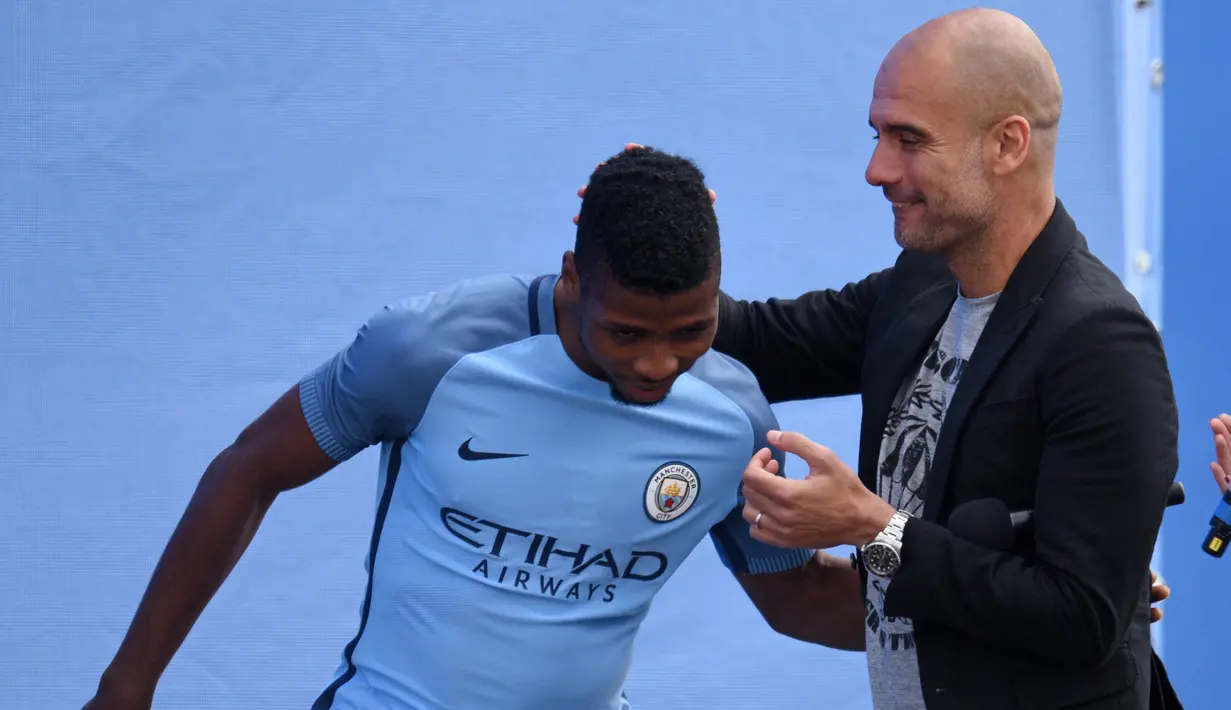 Pep Guardiola  terlihat bercanda dengan pemain anyar Manchester City, Kelechi Iheanacho (kiri) saat perkenalan di City Football Academy, Manchester, (3/7/2016). (AFP/Oli Scarf)