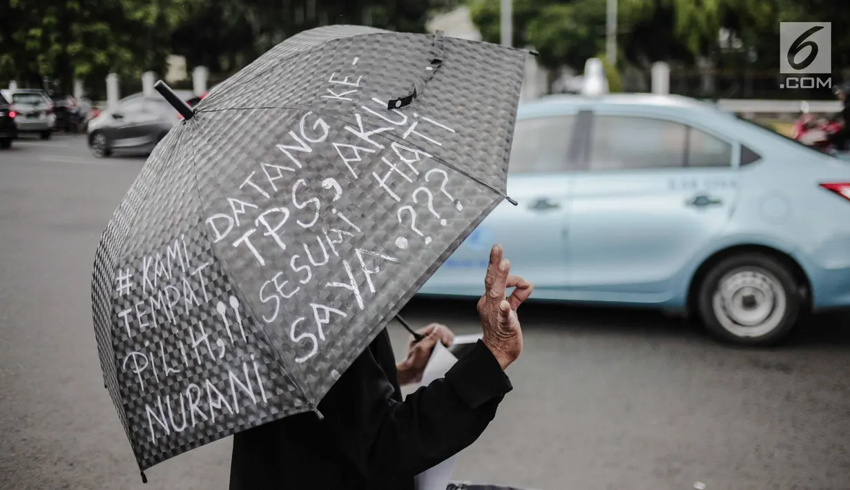 Aktivis Jaringan Solidaritas Korban untuk Keadilan (JSKK) membawa payung hitam saat menggelar aksi Kamisan ke-575 di depan Istana Merdeka, Jakarta, Kamis (21/2). Aktivis menolak kembalinya militer untuk menduduki jabatan sipil. (Liputan6.com/FaizalFanani)