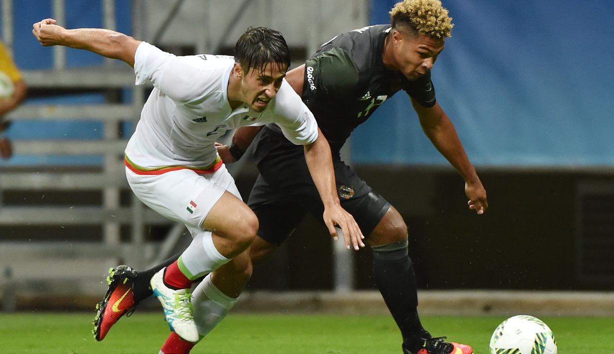 Pemain Meksiko, Jose Abella (kiri), berebut bola dengan pemain Jerman, Serge Gnabry, pada laga perdana Grup C Olimpiade Rio 2016 di Arena Fonte Nova, Jumat (5/8/2016) dini hari WIB. (AFP/Nelson Almeida)