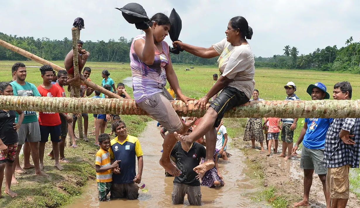 Dua wanita bertarung saat mengikuti perlombaan selama perayaan Tahun Baru Sinhala dan Tamil di Bandaragama, Kolombo (21/4). Sejumlah perlombaan diadakan saat tahun baru umat Hindu, Sinhala dan Tamil yang jatuh 14 April. (AFP Photo/Lakruwan Wannirachchi)