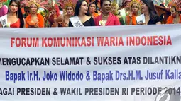 Para waria berjalan sambil membentangkan spaduk yang bertuliskan selamat atas dilantiknya Joko Widodo dan Jusuf Kalla sebagai Presiden dan Wakil Presiden, Jakarta, Minggu (2/11/2014). (Liputan6.com/Miftahul Hayat)
