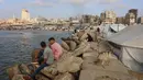 Warga Palestina yang mengungsi memanfaatkan pantai tersebut sebagai tempat untuk menghibur diri mereka di tengah berlangsungnya perang antara Israel dan milisi Hamas. (Omar AL-QATTAA/AFP)