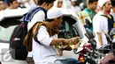 Seorang pengunjuk rasa makan siang diantara kerumunan massa sebelum memulai aksi di Medan Merdeka Timur, Jakarta, Jumat (4/11). (Liputan6.com/Faizal Fanani)