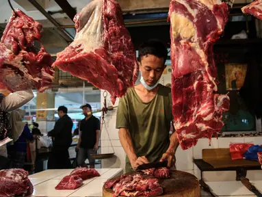 Pedagang memotong daging di Pasar Induk Kramat Jati, Jakarta, Kamis (8/4/2021). Pemerintah melalui Menteri Pertanian Syahrul Yasin Limpo, menegaskan, pihaknya siap melakukan intervensi jika stok daging langka dan terdapat lonjakan harga pada bulan Ramadan. (Liputan6.com/Johan Tallo)
