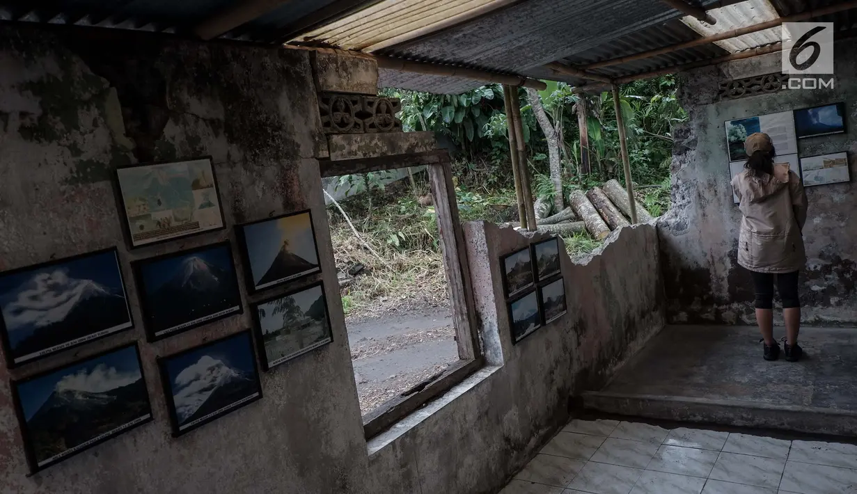 Pengunjung melihat foto dahsyatnya erupsi Gunung Merapi tahun 2010 di Galeri Sarsuadji, Sleman, Minggu (26/11). Di gaeleri ini terpajang sejumlah foto yang menggambarkan suasana saat peristiwa letusan Merapi pada 2010 lalu. (Liputan6.com/Faizal Fanani)