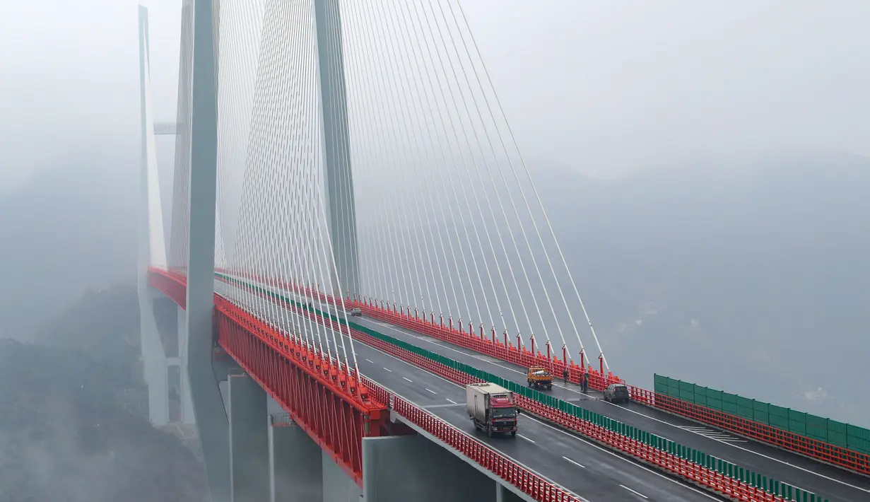 Kendaraan melintasi jembatan Beipanjiang di dekat Bijie, Provinsi Guizhou, barat daya China, 28 Desember 2016. Jembatanyang setara dengan ketinggian gedung 200 lantai itu itu menghubungkan provinsi Yunan dan Guizhou. (STR / AFP)