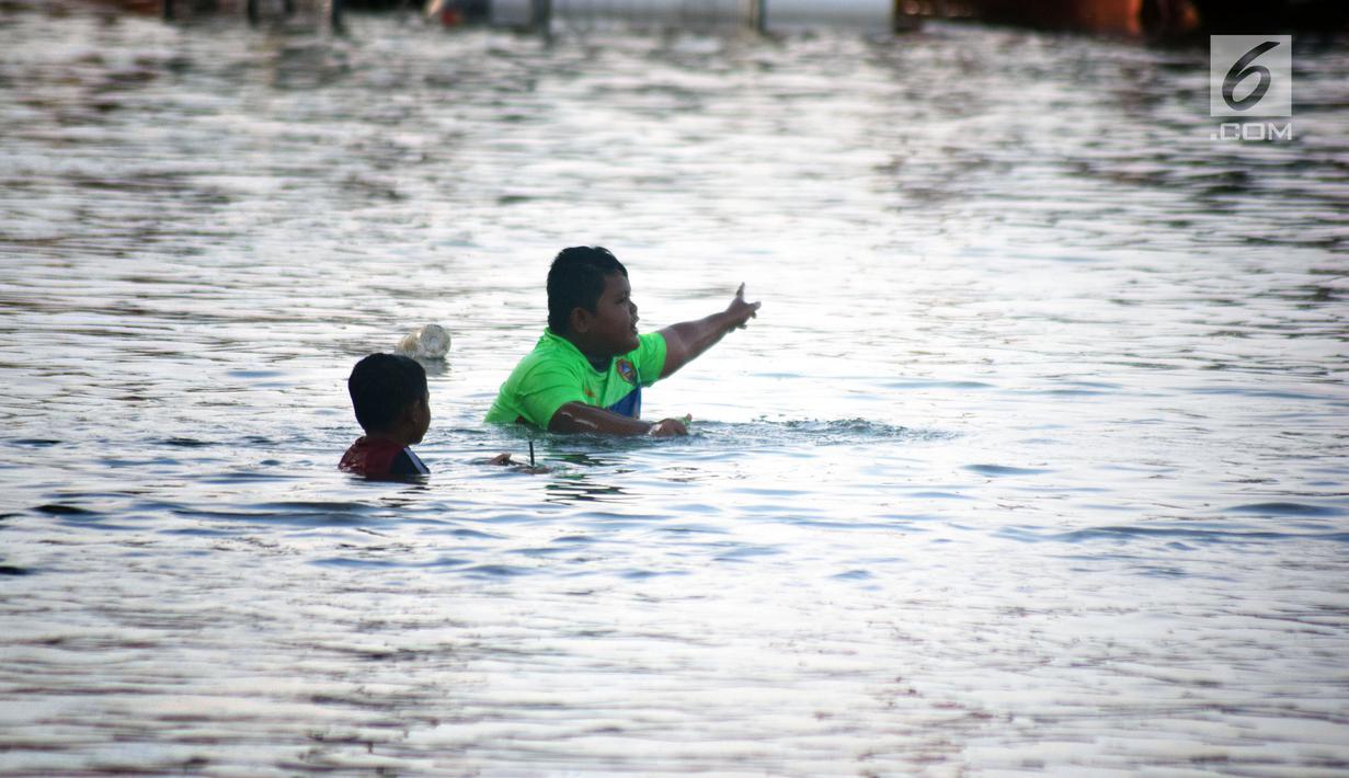 Dua bocah bermain air saat terjadi banjir rob di jalan Yos Sudarso Semarang di kawasan Pelabuhan Tanjung Emas (24/4). Banjir rob ini terjadi karena dipicu oleh salah satunya sistem drainase yang masih kurang baik. (Liputan6.com/Gholib)