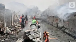 Warga bergotong royong mengambil air dari kali saat berusaha menjinakkan kebakaran di Jalan Kebon Jeruk 13, Taman Sari, Jakarta Barat, Minggu (6/10/2019). Kebakaran diduga akibat anak bermain korek api. (merdeka.com/Iqbal Nugroho)