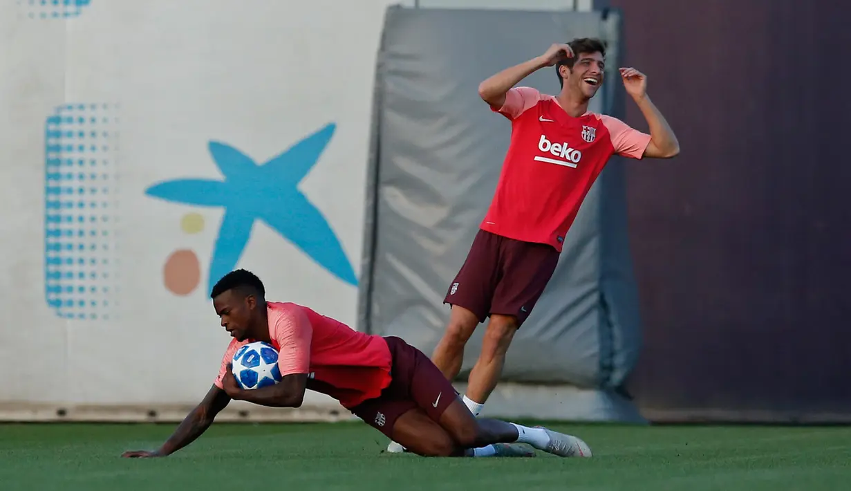 Pemain Barcelona Sergi Roberto (kanan) dan Nelson Semedo saat mengikuti sesi latihan di Barcelona, Spanyol (17/9). Barcelona akan bertanding melawan PSV Eindhoven pada grup B Liga Champions di Nou Camp. (AP Photo/Manu Fernandez)