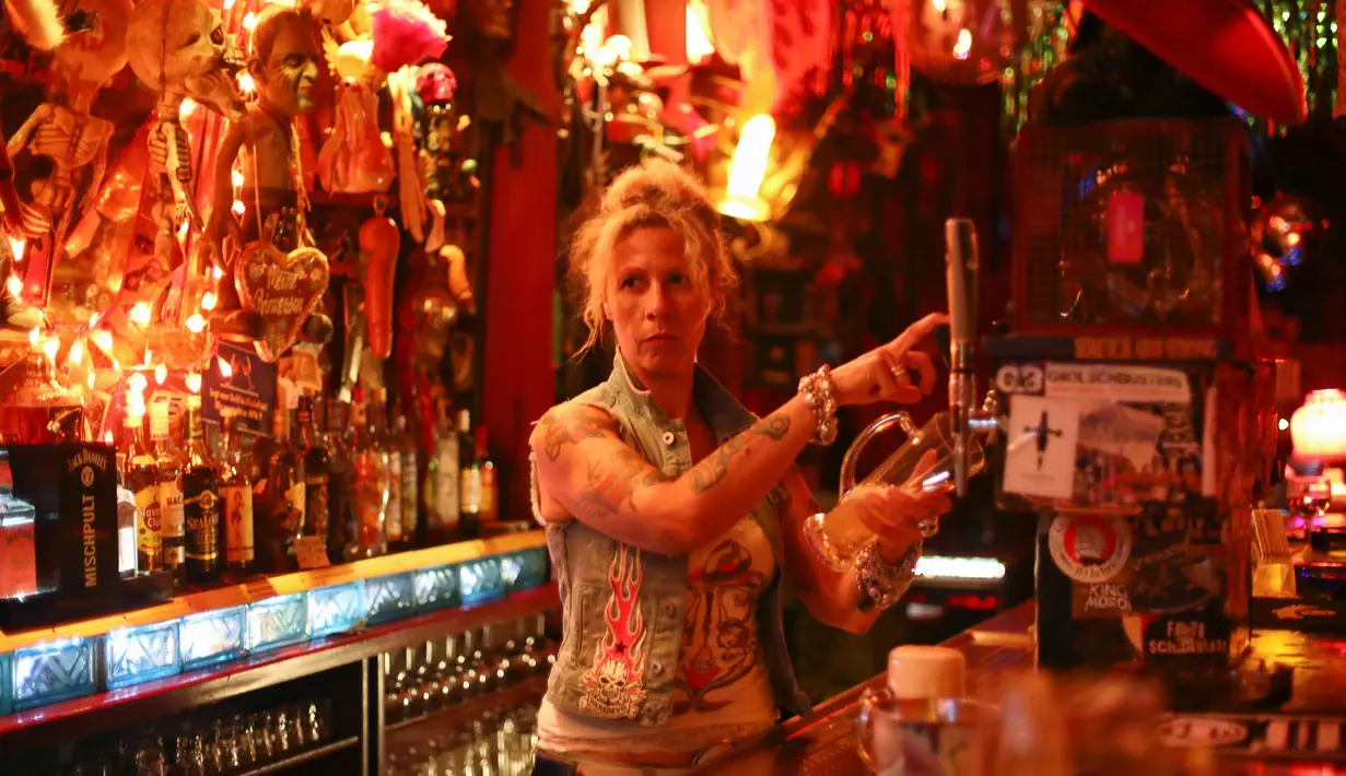 Lea, pemilik Klub Wild at Heart menyajikan minuman untuk tamunya, di Berlin, Jerman, (1/9).  Lea dan suaminya Uli, telah menjalankan kelab "Wild at Heart" selama lebih dari 20 tahun. (REUTERS/Hannibal Hanschke)