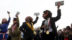 Para demonstran mengenakan kostum pejabat dan topeng sambil menghambur-hamburkan uang berunjuk rasa anti korupsi untuk memprotes pencalonan presiden Peru, Keiko Fujimori di Kota Lima, Peru (5/4). (REUTERS/Guadalupe Pardo)