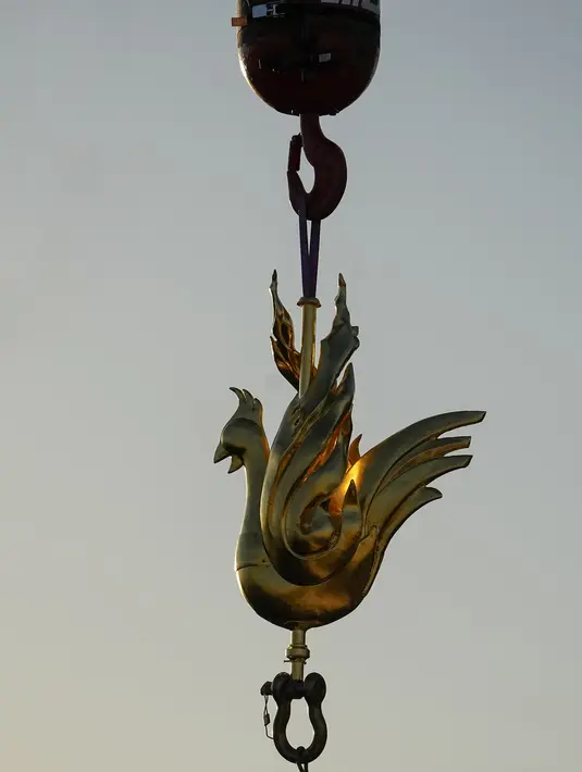 Ayam jantan emas ini berisi relik-relik yang diselamatkan dari kebakaran yang melanda monumen tersebut pada 15 April 2019, dan sebuah dokumen berisi nama-nama orang yang mengerjakan rekonstruksi. (AP Photo/Michel Euler)