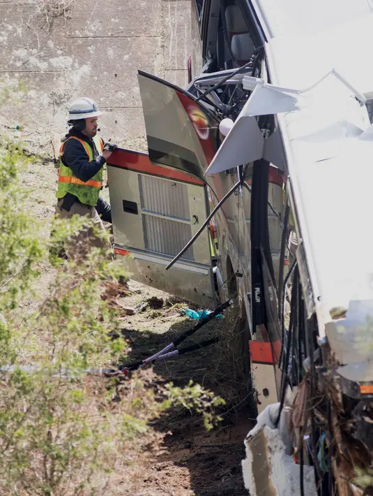 Seorang petugas berusaha mengevakuasi korban di dalam bangkai bus carteran yang kecelakaan di Loxley, Alabama (13/3). Bus tersebut membawa anggota band SMA di Texas pulang dari Disney World. (Gregg Pachkowski/Pensacola News Journal via AP)