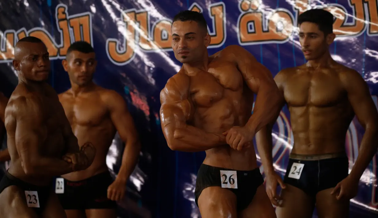 Kontestan memamerkan otot mereka saat tampil di atas panggung kompetisi binaraga lokal di Kota Gaza pada Minggu (15/9/2019). Kompetisi ini diikuti oleh sejumlah pria Palestina. (AP Photo/Hatem Moussa)