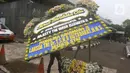 Petugas berjalan membawa karangan bunga duka cita atas meninggalnya Ratu Elizabeth II untuk diletakkan di depan Kedutaan Besar (Kedubes) Inggris, kawasan Kuningan, Jakarta, Jumat (9/9/2022).  Sebuah pernyataan dari Keluarga Kerajaan di Twitter mengatakan ratu yang dihormati itu meninggal dengan damai. (Liputan6.com/Herman Zakharia)