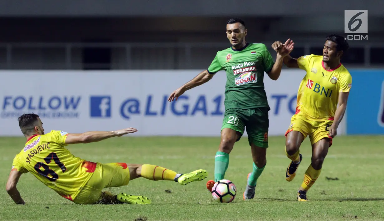 Pemain tengah PS TNI, Redouane Zerzouri (tengah) mencoba lolos dari kawalan pemain Bhayangkara FC saat lanjutan Liga 1 Indonesia di Stadion Pakansari, Kab Bogor, Minggu (3/9). Bhayangkara FC unggul 1-0. (Liputan6.com/Helmi Fithriansyah)