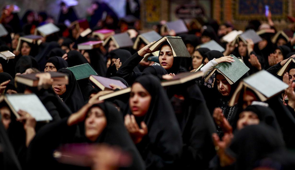 <p>Para wanita Syiah menaruh mushaf Alquran di atas kepala mereka saat menghadiri sholat lailatulqadar pada bulan suci Ramadhan. (AP Photo/Anmar Khalil)</p>