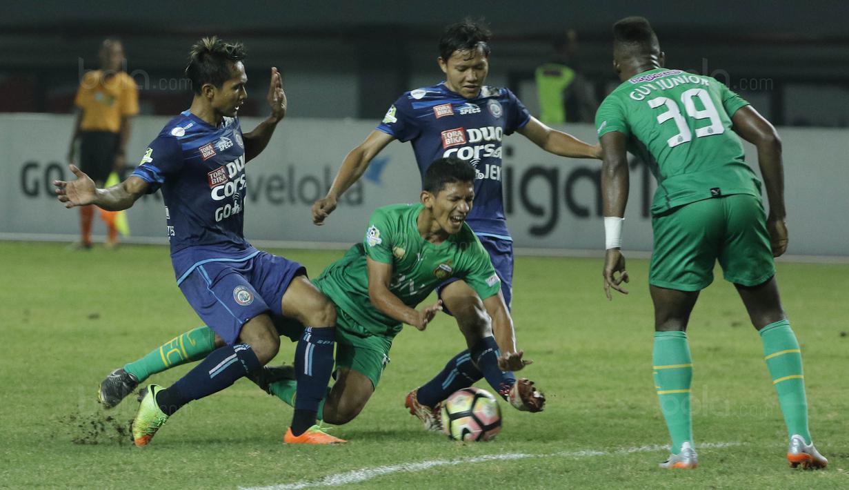 Gelandang Bhayangkara FC, TM Ichsan, terjatuh saat berebut bola dengan pemain Arema FC, Adam Alis, pada laga Liga 1 di Stadion Patriot, Bekasi, Jumat (4/8/2017). Bhayangkara FC menang 2-1 atas Arema FC. (Bola.com/M Iqbal Ichsan)