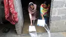 Dua wanita membuang air dari rumah mereka setelah hujan deras di Karachi, Pakistan, Selasa (30/7/2019). Hujan deras terjadi pada hari Senin dan berlanjut pada hari Selasa dan air limbah membanjiri sebagian besar jalan di Karachi, ibukota provinsi Sindh selatan. (AP/Photo/Fareed Khan)