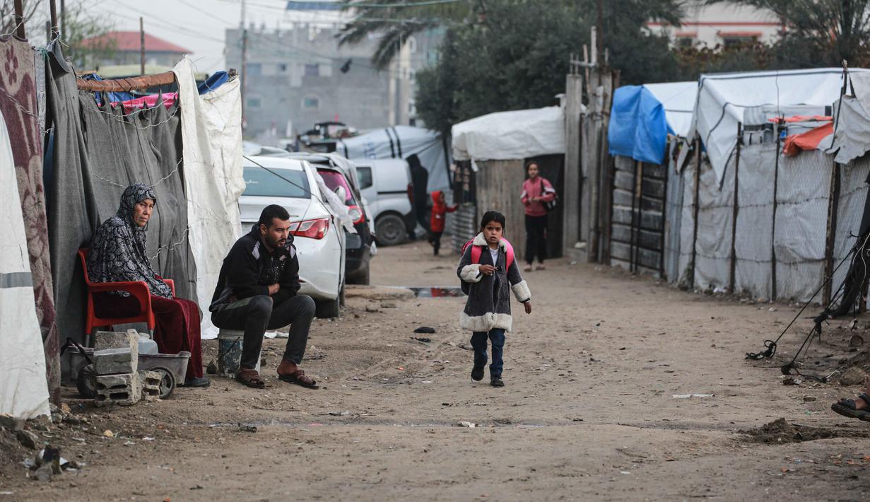 Meskipun dalam kondisi yang sangat sulit dan terbatas, setelah terhentinya pendidikan formal selama lebih dari dua tahun akibat perang antara Israel dan Hamas. Tampak dalam foto, seorang gadis kecil berjalan ke sekolah di Deir al-Balah, di Jalur Gaza tengah, pada 10 Desember 2025. (BASHAR TALEB/AFP)