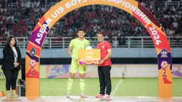 Kiper Timnas Indonesia U-19, Ikram Algiffari berfoto dengan trofi kiper terbaik Piala AFF U-19 2024 usai laga final di Stadion Gelora Bung Tomo, Surabaya, Senin (29/7/2024). (Bola.com/Bagaskara Lazuardi)