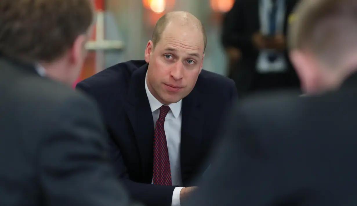 Pangeran William dari Inggris berbincang dengan veteran militer saat mengunjungi para pasien anak-anak di Evelina London Children's Hospital, Kamis (18/1). Pangeran William muncul mencuri perhatian dengan potongan rambut baru (Daniel LEAL-OLIVAS/POOL/AFP)