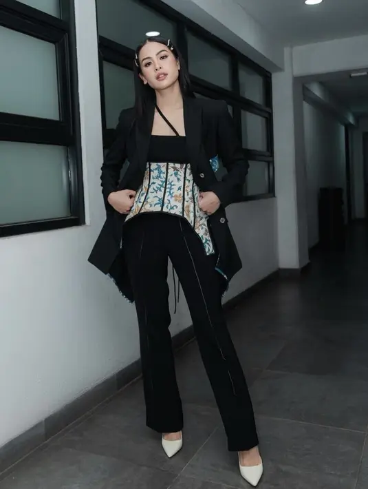 Maudy Ayunda tampil simple hanya mengenakan blazer dan celana hitam, namun gayanya tampak mewah dengan korset motif batiknya. @maudyayunda