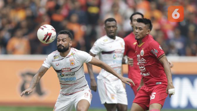 Bek Persija Jakarta, Maman Abdurahman, berebut bola dengan pemain Borneo FC, Francisco Torres, pada laga Shopee Liga 1 di SUGBK, Jakarta, Minggu, (1/3/2020). Persija menang 3-2 atas Borneo FC. (Bola.com/M Iqbal Ichsan)