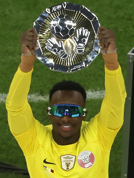 Kiper Qatar, Meshaal Barsham mengangkat trofi pengharagaan penjaga gawang terbaik Piala Asia 2023 di Lusail Stadium, Doha, Qatar, Sabtu (10/02/2024). (AFP/Karim Jaafar)