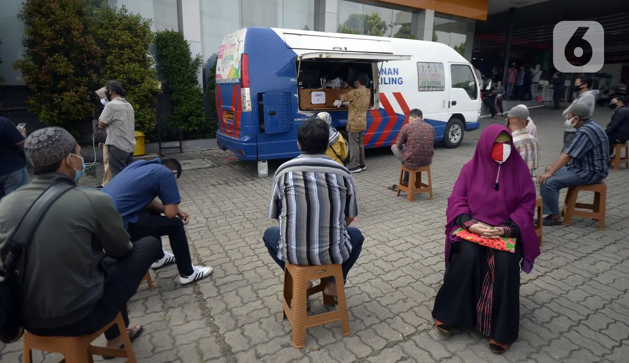 Warga antre mengurus SIM di Pelayanan SIM Keliling, Tangerang Selatan, Banten, Jumat (7/8/2020). Ditlantas Polda Metro Jaya memberi dispensasi bagi pemilik SIM yang masa berlakunya habis di masa pandemi COVID-19 bisa memperpanjang sampai akhir Agustus 2020. (merdeka.com/Dwi Narwoko)