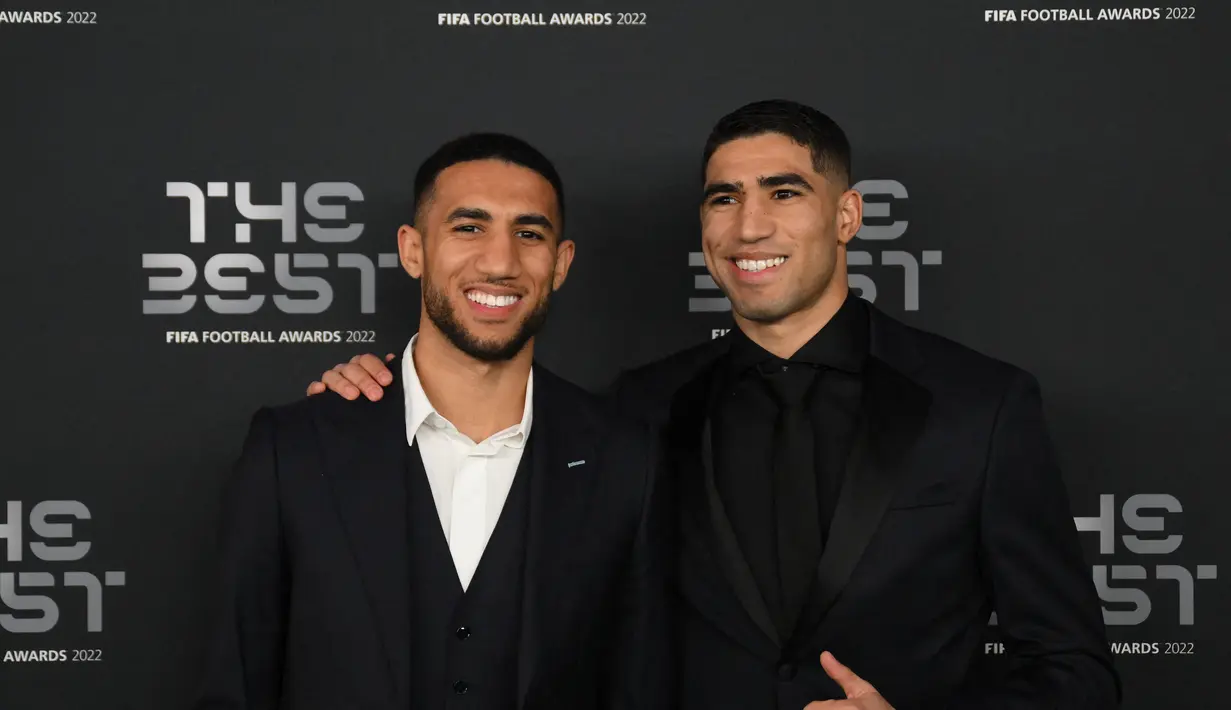 Bek Maroko Achraf Hakimi (kanan) dan saudaranya Nabil berpose setibanya untuk menghadiri upacara Penghargaan The Best FIFA Football Awards 2022 di Paris, Prancis, 27 Februari 2023. Insiden dugaan pemerkosaan itu terhenti setelah wanita yang tidak diketahui identitasnya tersebut mendorongnya dan berhasil melarikan diri. (AFP/Franck Fife)