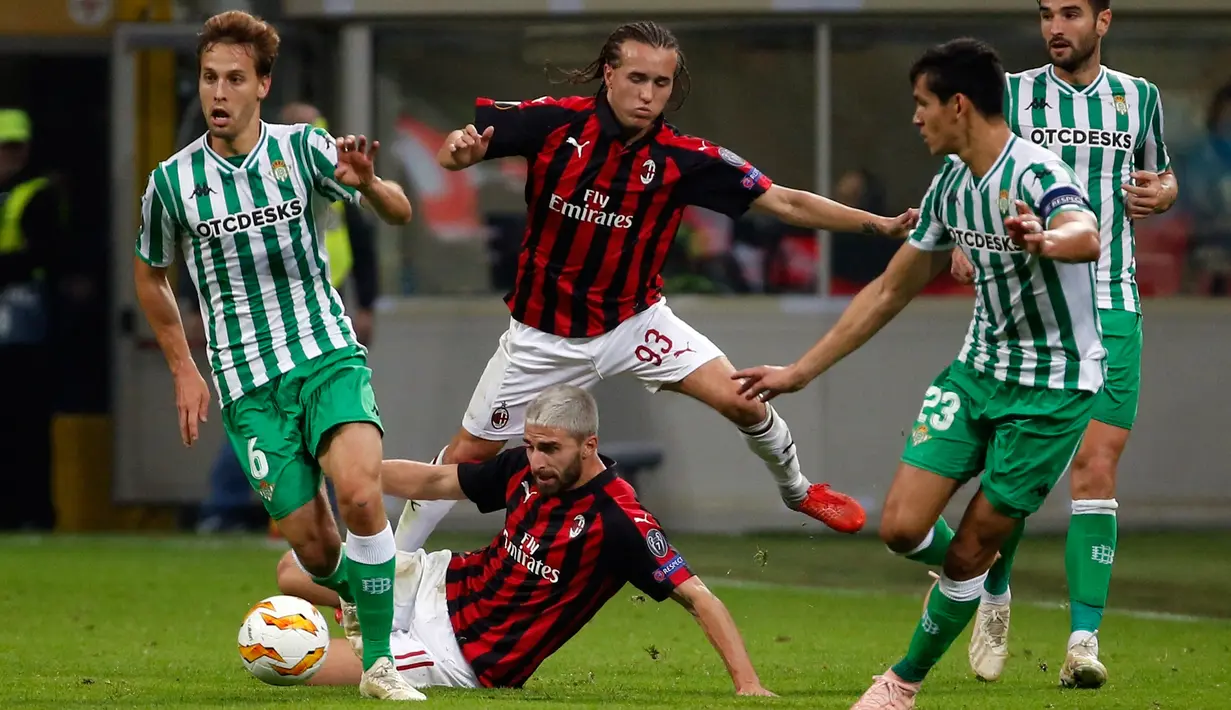 Pemain Real Betis, Sergio Canales (kiri) membawa bola melewati pemain AC Milan Fabio Borini dan Diego Laxalt saat bertanding dalam Grup F Liga Europa di Stadion San Siro, Milan, Italia, Kamis (25/10). AC Milan kalah 1-2. (AP Photo/Antonio Calanni)