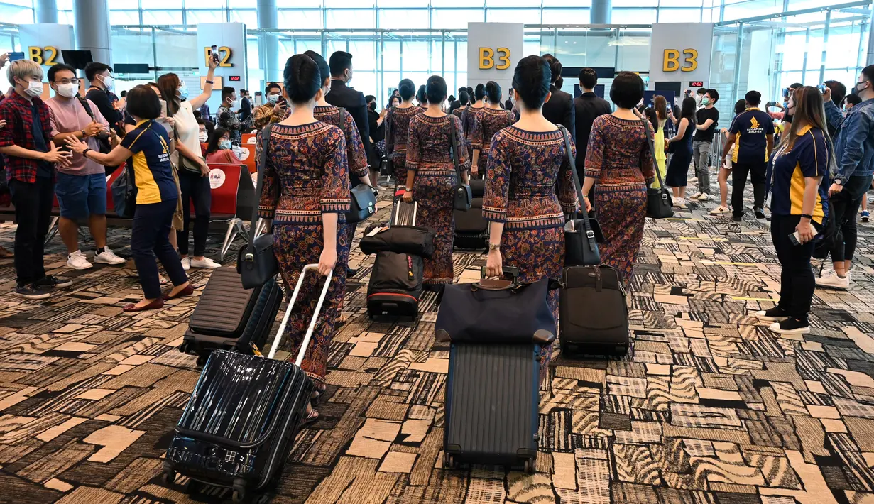 <p>Awak Singapore Airlines tiba untuk bertugas selama makan siang perdana di Restaurant A380 @Changi di pesawat Airbus A380, di Bandara Internasional Changi, 24 Oktober 2020. Maskapai penerbangan ini mengubah salah satu pesawatnya menjadi sebuah restoran mewah. (ROSLAN RAHMAN/AFP)</p>