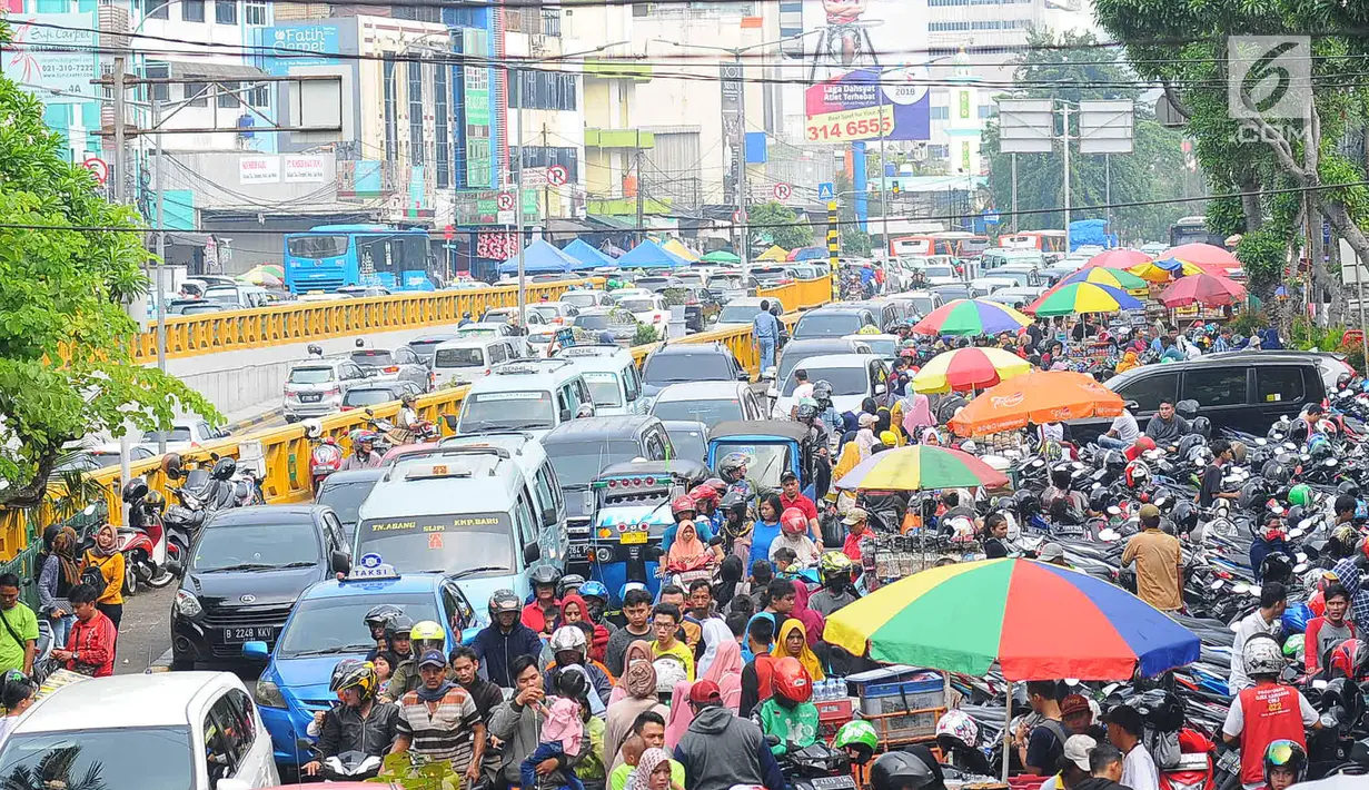 Sejumlah mobil terjebak kemacetan di kawasan Tanah Abang, Jakarta, Minggu (26/5/2019). Banyaknya masyarakat yang berbelanja di pasar tanah abang membuat arus lalu lintas di kawasan tersebut padat. (Liputan6.com/Angga Yuniar)