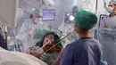 Gambar yang direkam pada 31 Januari 2020, musisi Dagmar Turner bermain biola saat berlangsungnya operasi pengangkatan tumor otak di King's College Hospital, London. Ini dilakukan untuk mempertahankan keahlian Turner dalam bermain biola, hobinya sejak usia 10 tahun. (KING'S COLLEGE HOSPITAL/AFP)