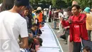 Sejumlah warga melakukan tanda tangan di bentangan sapanduk panjang di Bundaran HI, Jakarta, Minggu (16/4). Ratusan tanda tangan tersebut di bentuk untuk mendukung pilkada DKI Jakarta yang damai dan tidak golput. (Liputan6.com/Angga Yuniar)