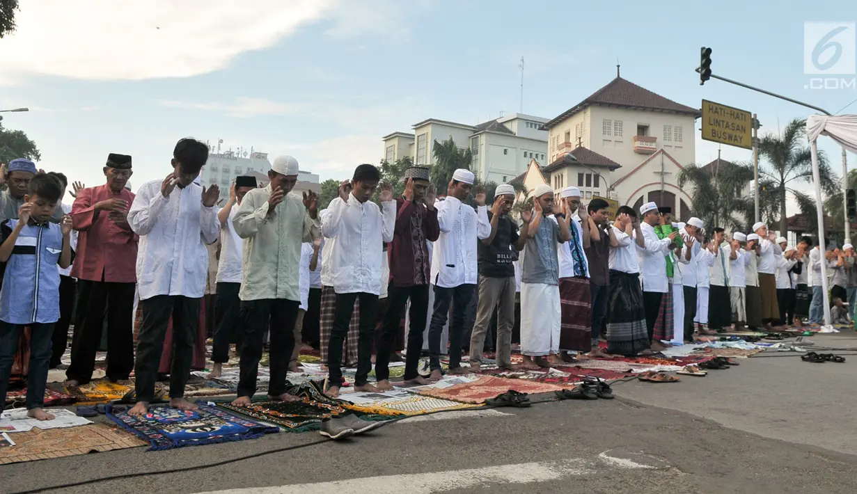 Umat muslim bersiap melaksanakan salat Idul Fitri 1438 H di jalanan kawasan Jatinegara, Jakarta, Minggu (25/7). Ruas Jalan Jatinegara Barat disulap menjadi tempat pelaksanaan salat Ied. (Liputan6.com/Yoppy Renato)