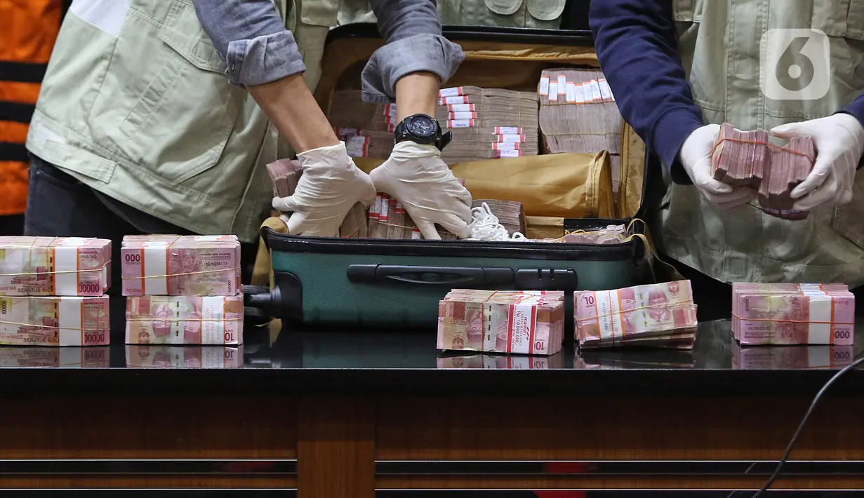 Petugas menunjukkan barang bukti pada jumpa pers Operasi Tangkap Tangan (OTT) Gubernur Sulawesi Selatan di gedung KPK, Jakarta, Minggu (28/2/2021) dini hari. KPK menyita koper berisi Rp 2 Miliar dalam OTT terhadap Gubernur Sulawesi Selatan Nurdin Abdullah. (Liputan6.com/Herman Zakharia)