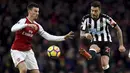 Pemain Arsenal, Laurent Koscielny (kiri)  berusaha menghalau bola sepakan pemain Newcastle United, Joselu pada lanjutan Premier League di Emirates Stadium, London, (16/12/2017). Arsenal menang 1-0.  (Joe Giddens/PA via AP)