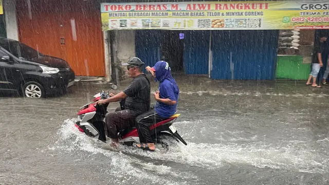 Pengendara sepeda motor melintas banjir di Jalan Keadilan Raya, Depok. (Liputan6.com/Dicky Agung Prihanto)